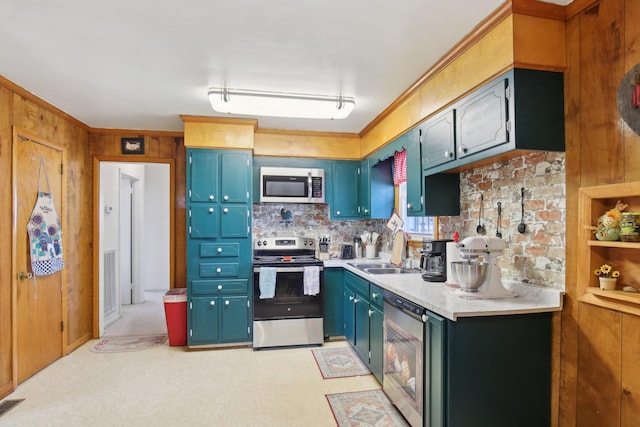 kitchen with wine cooler, light countertops, appliances with stainless steel finishes, a sink, and wooden walls