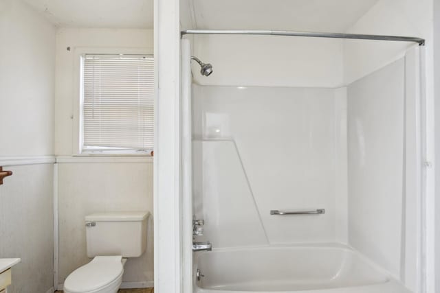 bathroom with a wainscoted wall, bathing tub / shower combination, vanity, and toilet