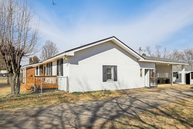 view of side of home featuring brick siding and fence