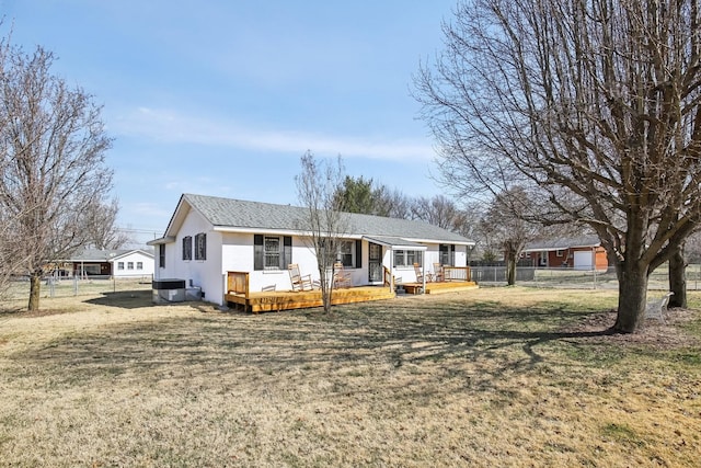 view of front of home featuring central air condition unit, a front lawn, fence, and a deck