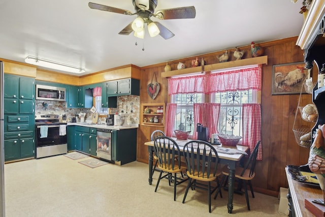 kitchen featuring light countertops, appliances with stainless steel finishes, wood walls, and a sink