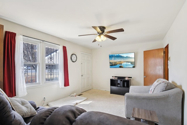 living area with light carpet and ceiling fan