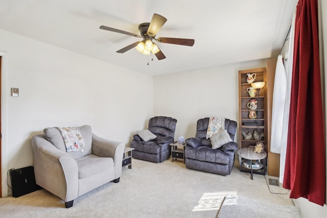 living area featuring ceiling fan and light colored carpet