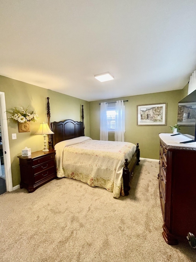 bedroom with light carpet and baseboards