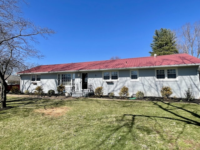 view of front of home featuring brick siding, metal roof, and a front lawn