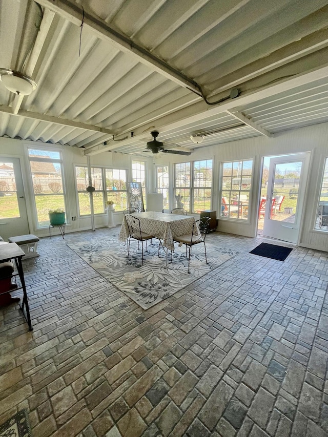 unfurnished sunroom featuring a ceiling fan