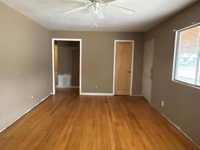 unfurnished bedroom featuring a textured ceiling, light wood finished floors, and a ceiling fan