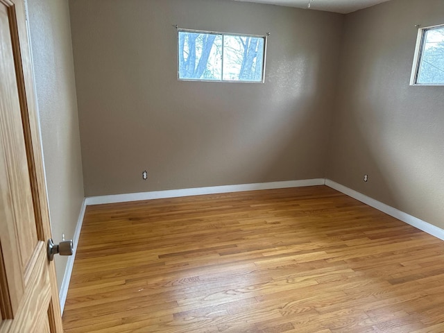 empty room with light wood-style flooring and baseboards