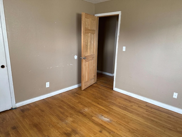 empty room featuring baseboards and wood finished floors