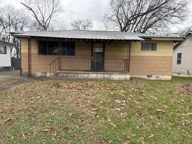 view of front facade with a front yard, crawl space, covered porch, and metal roof