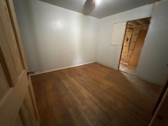 empty room with baseboards and wood finished floors