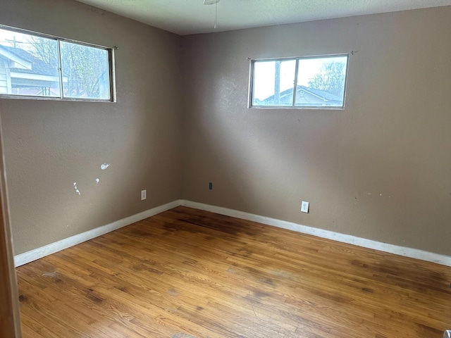 spare room featuring wood finished floors and baseboards