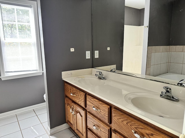 full bathroom featuring a garden tub, double vanity, tile patterned flooring, and a sink