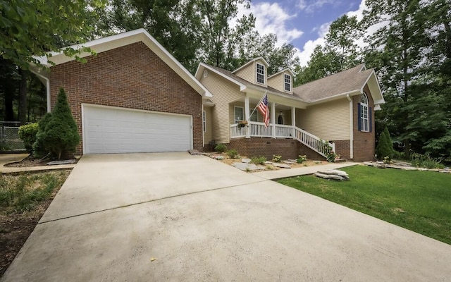 view of front of property featuring brick siding, covered porch, a garage, driveway, and a front lawn