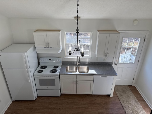 kitchen with white appliances, plenty of natural light, dark wood-type flooring, and a sink