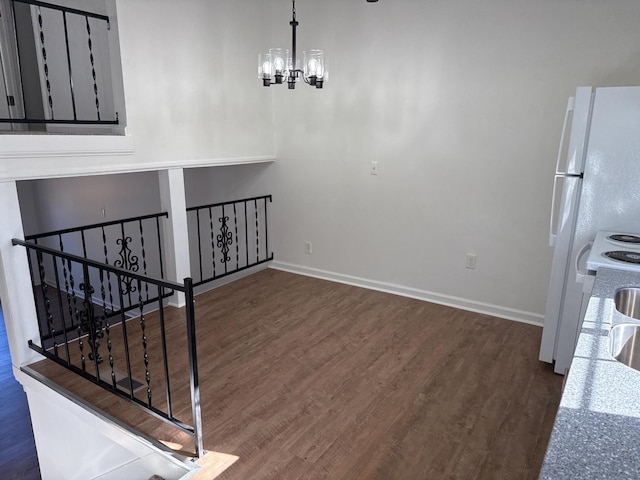 interior space featuring a chandelier, baseboards, and wood finished floors