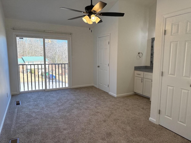 unfurnished bedroom with access to exterior, visible vents, a ceiling fan, light carpet, and baseboards