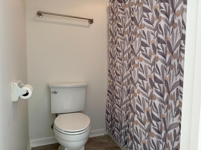 full bathroom featuring toilet, curtained shower, and baseboards