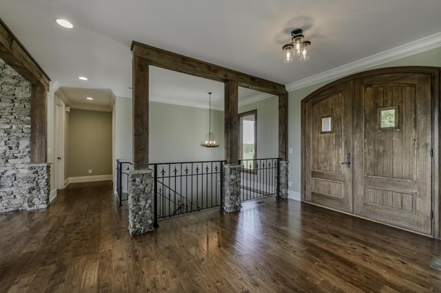 entryway featuring crown molding, baseboards, wood finished floors, and an inviting chandelier