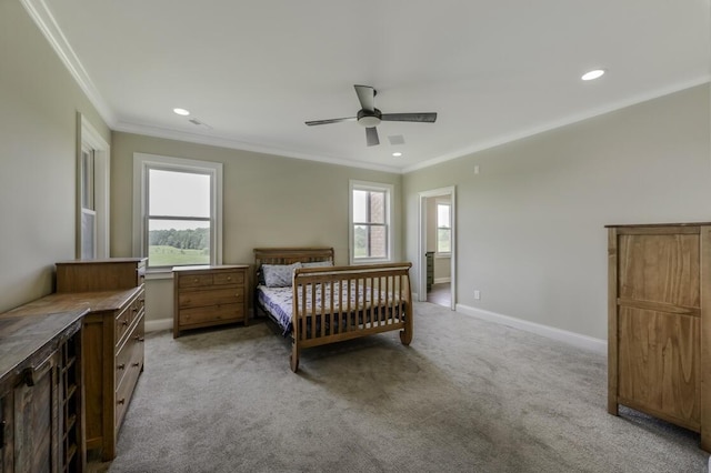 bedroom with baseboards, crown molding, multiple windows, and light colored carpet