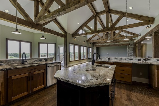 kitchen featuring pendant lighting, open floor plan, a sink, and stainless steel dishwasher