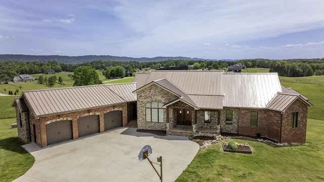 view of front of house with brick siding, metal roof, an attached garage, a standing seam roof, and a front yard