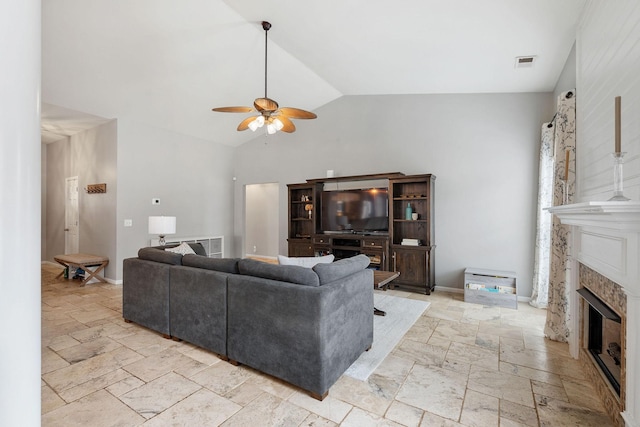 living room featuring stone tile floors, a fireplace, visible vents, and baseboards