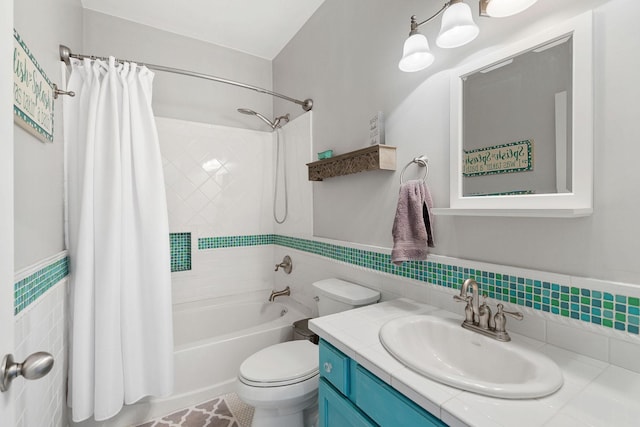 full bathroom featuring toilet, vanity, tile walls, wainscoting, and shower / bath combination with curtain