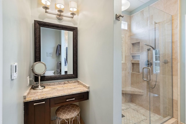 bathroom with a shower stall and vanity