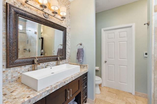 full bathroom with baseboards, decorative backsplash, tiled shower, toilet, and vanity