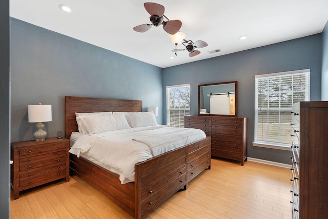 bedroom featuring multiple windows, visible vents, and light wood-style floors