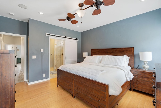 bedroom featuring a barn door, light wood-style flooring, recessed lighting, a ceiling fan, and baseboards