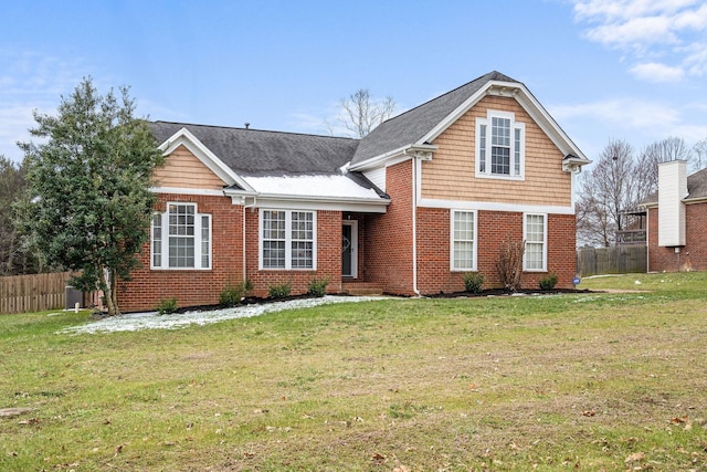 view of front of property with a front yard, fence, and brick siding