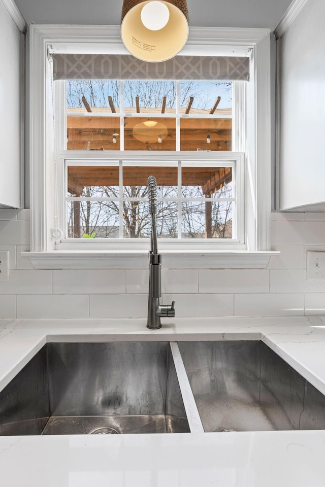 details with light stone counters, decorative backsplash, and a sink