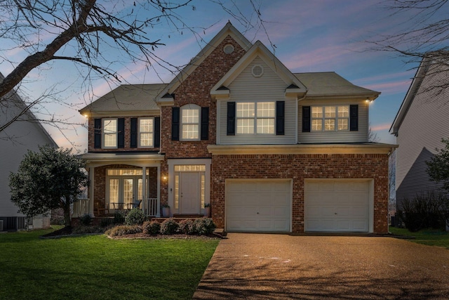 view of front facade with an attached garage, brick siding, driveway, and a front lawn