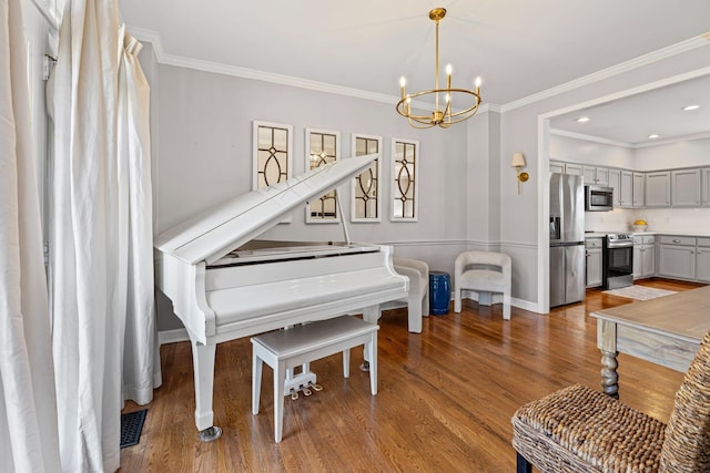 sitting room with visible vents, ornamental molding, wood finished floors, a chandelier, and baseboards