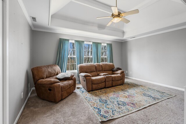 carpeted living room with a tray ceiling, visible vents, and baseboards