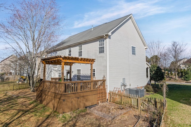 rear view of property featuring a yard, central AC unit, fence, a deck, and a pergola