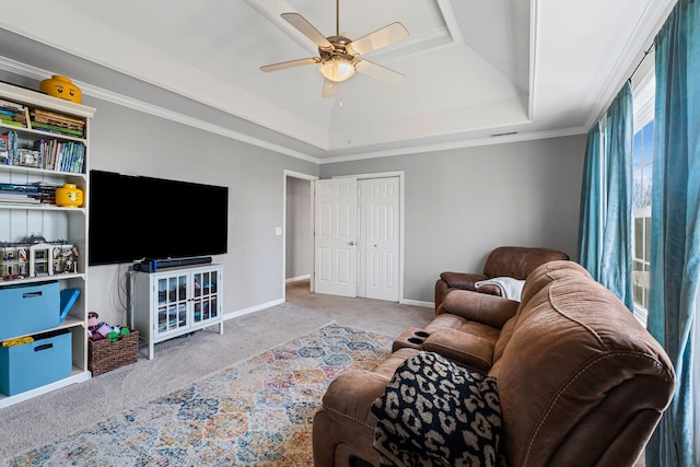 living area featuring ceiling fan, baseboards, carpet, a raised ceiling, and crown molding