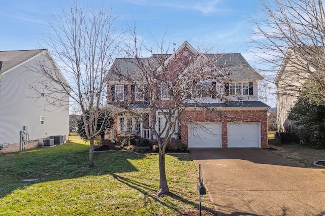 view of front facade with driveway, an attached garage, a front yard, central AC, and brick siding