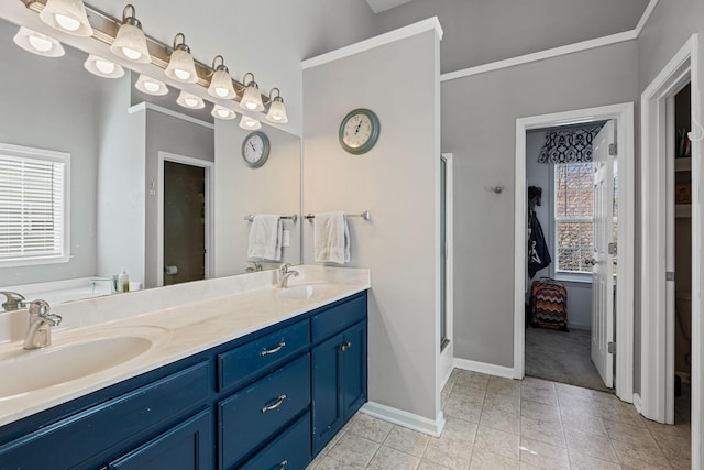 full bath with double vanity, a stall shower, a sink, and baseboards