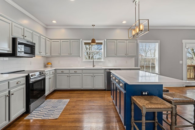 kitchen featuring stainless steel appliances, a breakfast bar, dark wood-type flooring, and crown molding