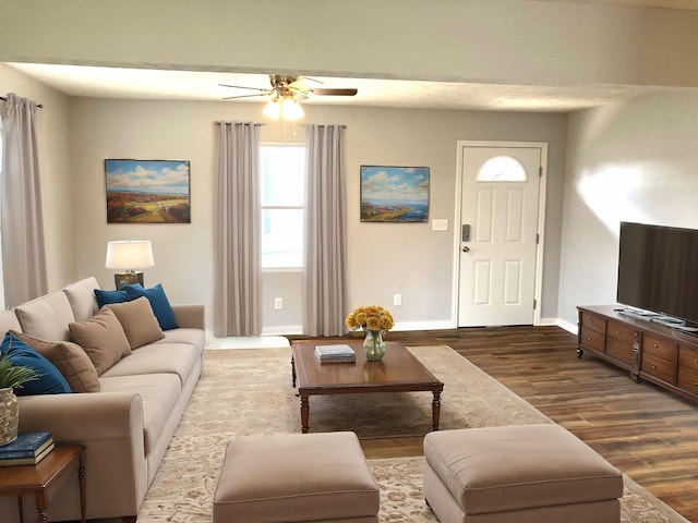 living room with dark wood finished floors, baseboards, and ceiling fan