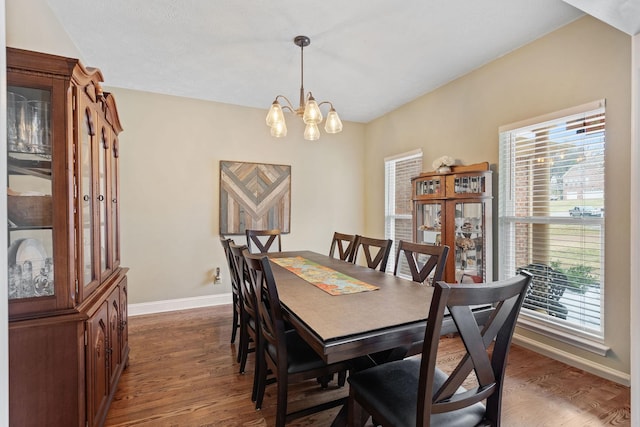 dining area with an inviting chandelier, dark wood finished floors, and baseboards