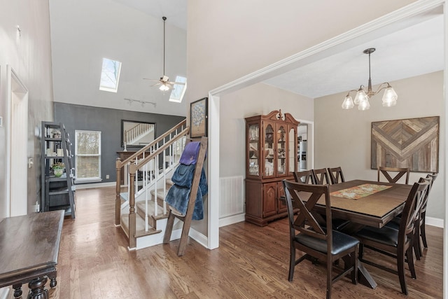 dining area with visible vents, stairway, a high ceiling, and wood finished floors