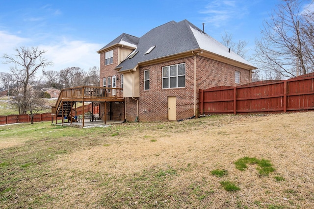 rear view of house with a fenced backyard, brick siding, stairs, a yard, and a patio area