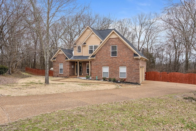 view of front facade featuring brick siding, fence, and roof with shingles