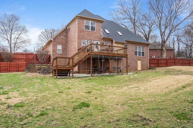 rear view of house with a wooden deck, a fenced backyard, stairs, a yard, and brick siding