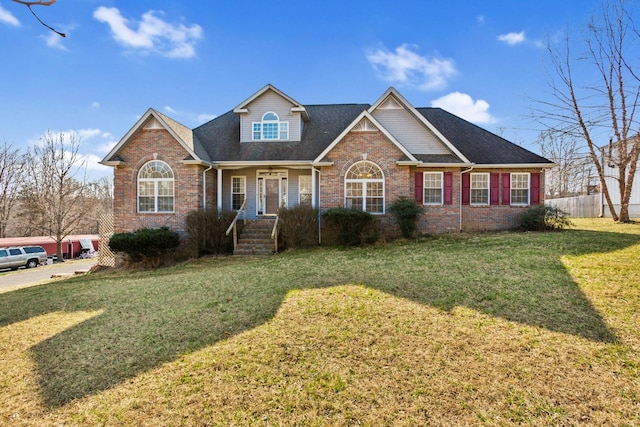 view of front of house featuring a front lawn, fence, and brick siding