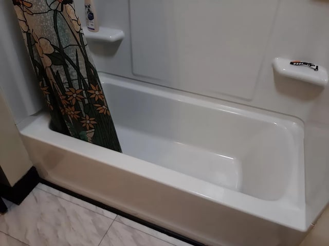 room details featuring curtained shower and a tub